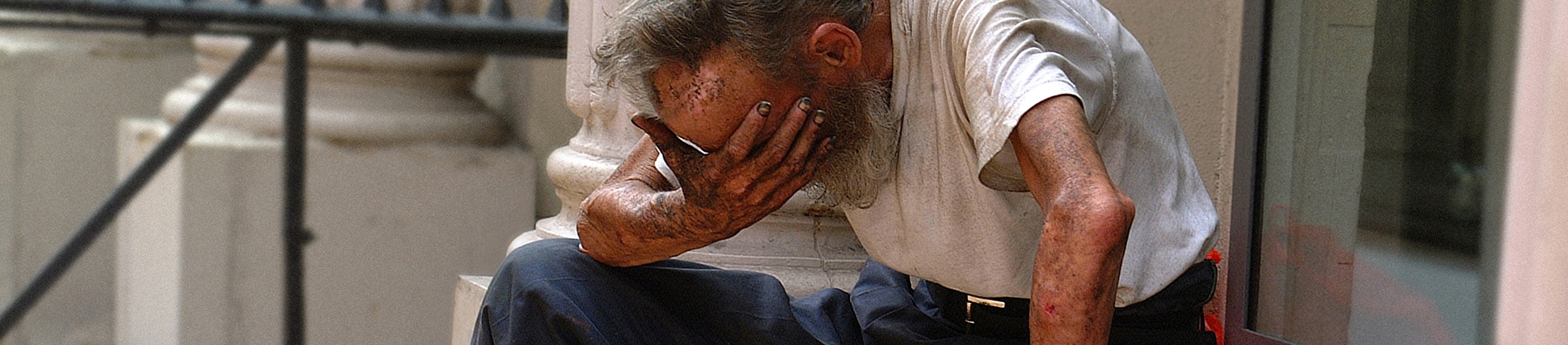 A older man sat on some steps with his head in his hand covered in dirt A older man sat on some steps with his head in his hand covered in dirt