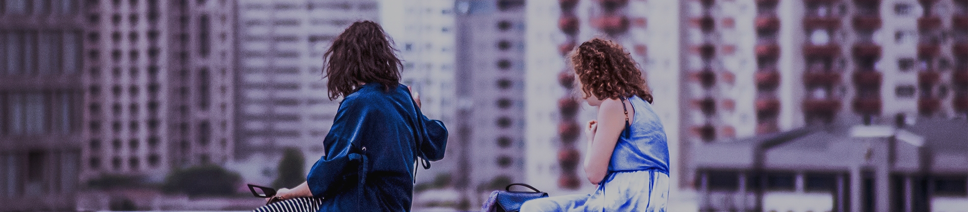Two friends sat looking over a cityscape Two friends sat looking over a cityscape