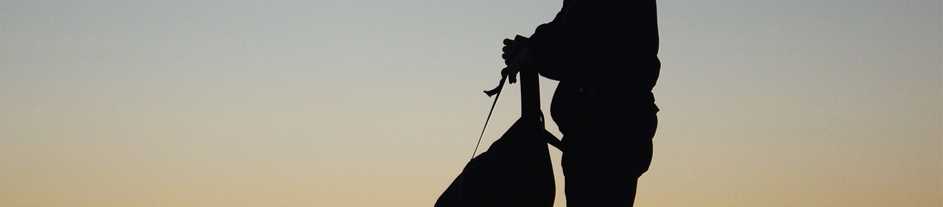 A silhouette of a man holding a backpack