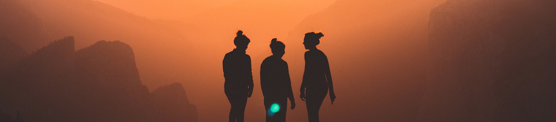 Silhouette of three friends with the sun setting behind them Silhouette of three friends with the sun setting behind them