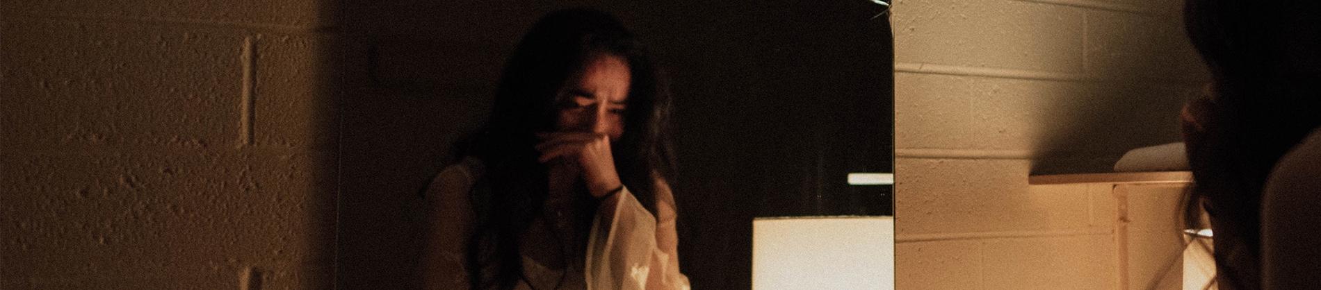 A crying women looking into a mirror on a wall A crying women looking into a mirror on a wall