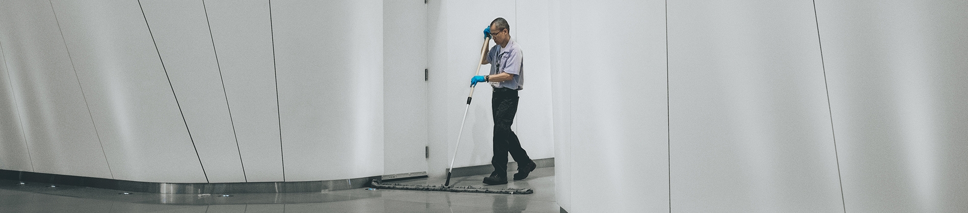 A cleaner mopping the floor of a office building A cleaner mopping the floor of a office building