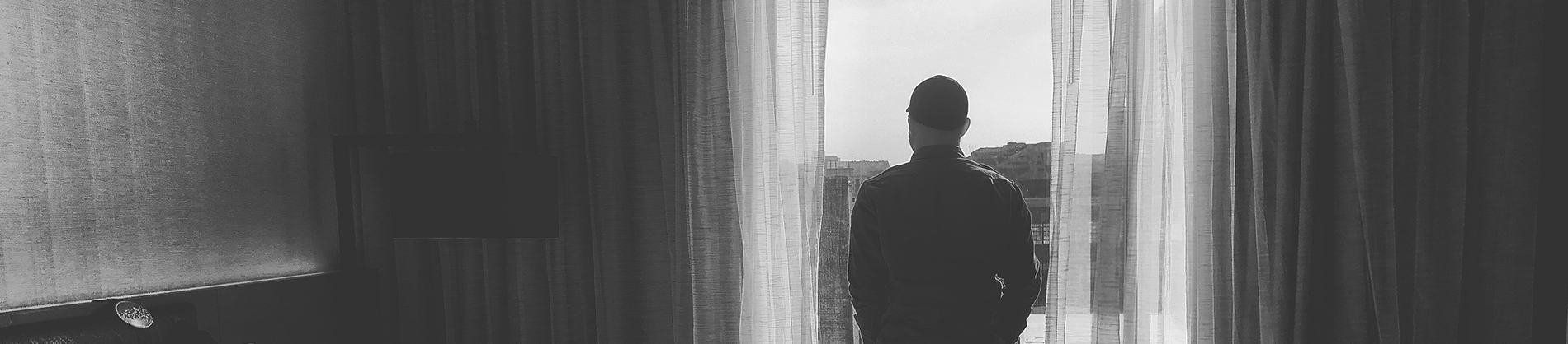 A man looking out of a door into the distance A man looking out of a door into the distance