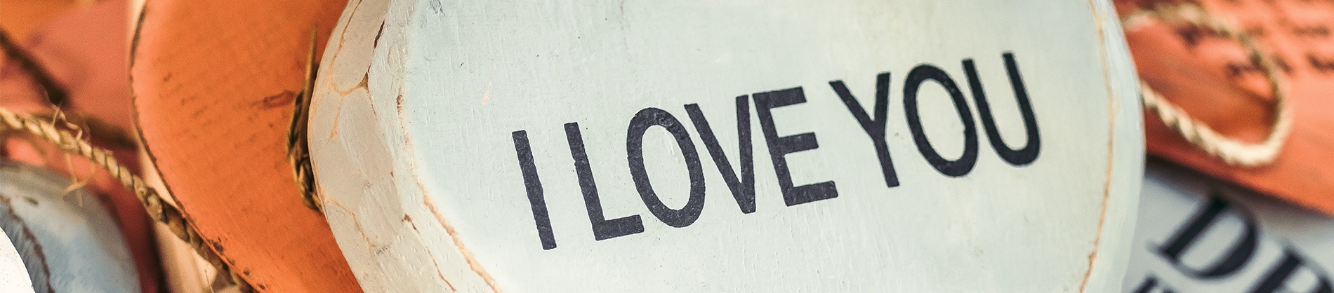 Orange and white wooden hand up signs with 'I Love You' engraved Orange and white wooden hand up signs with 'I Love You' engraved