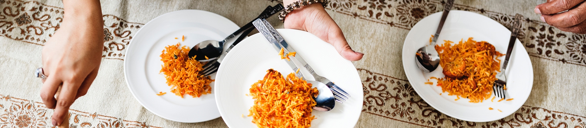 A women serving food onto plates A women serving food onto plates