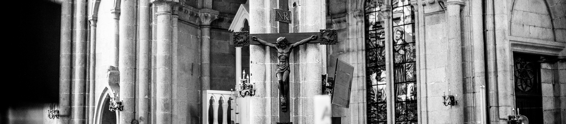 Black and white photo of a church with a statue of Jesus on the cross on the wall Black and white photo of a church with a statue of Jesus on the cross on the wall