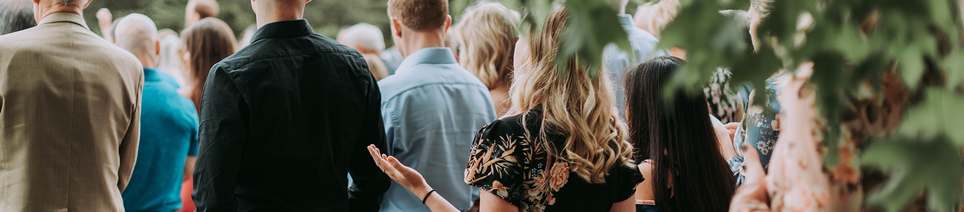 A group of people stood together with one women with her hands out A group of people stood together with one women with her hands out