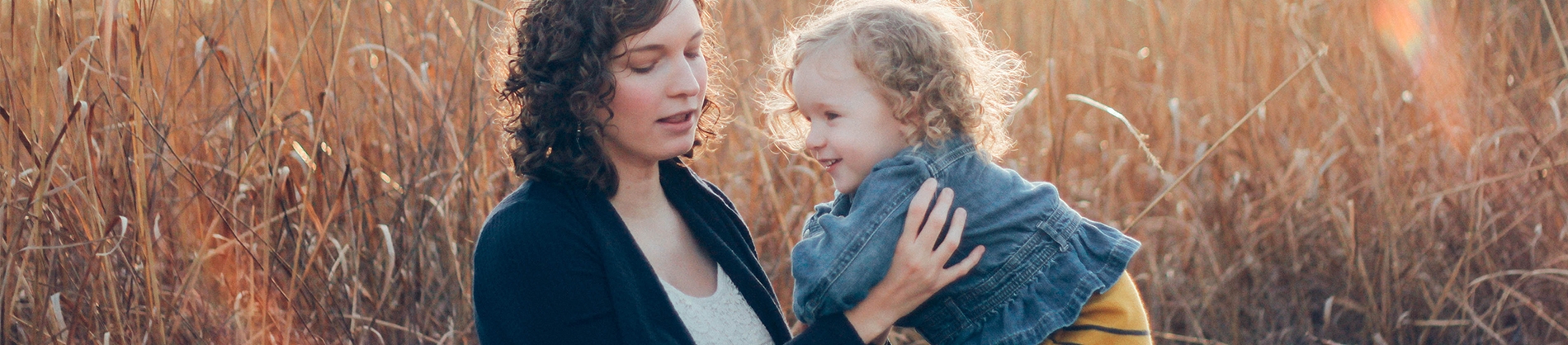 A women holding her child in a the middle of a field