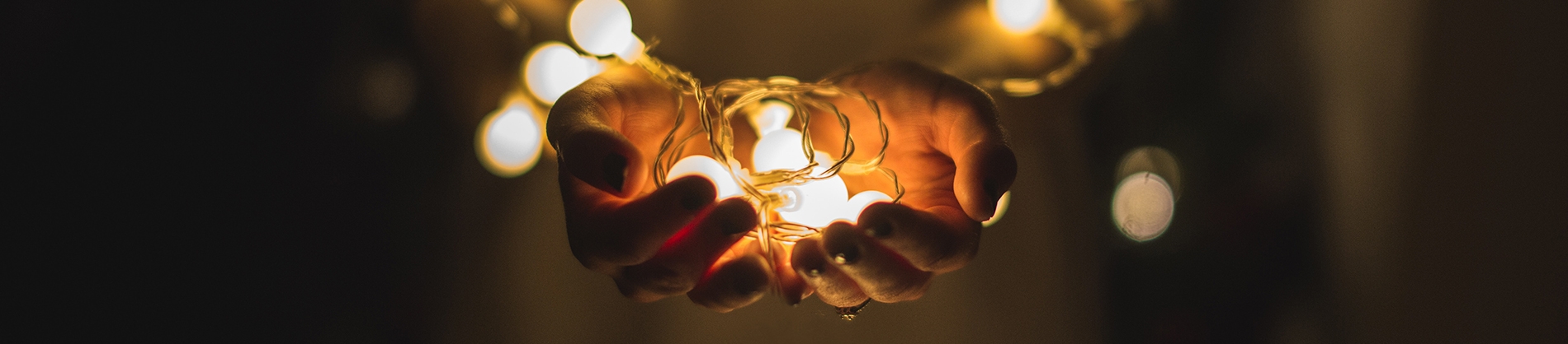 A women holding lit up lightbulbs in her hands A women holding lit up lightbulbs in her hands