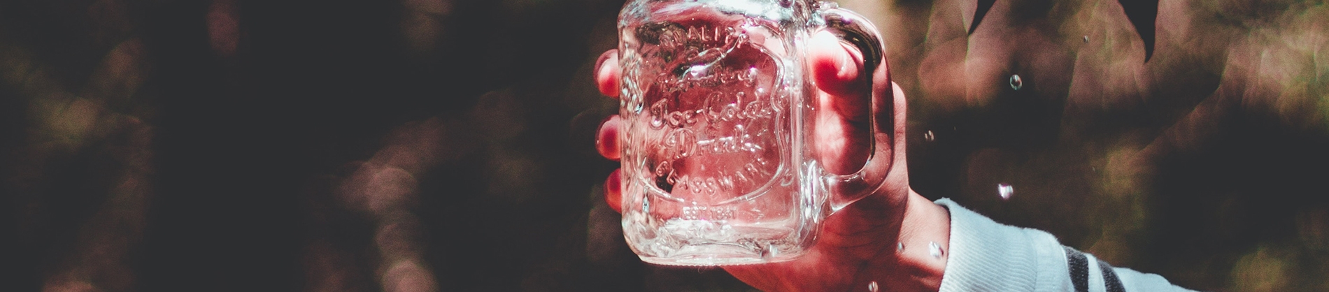 Someone holding up a glass mason jar Someone holding up a glass mason jar
