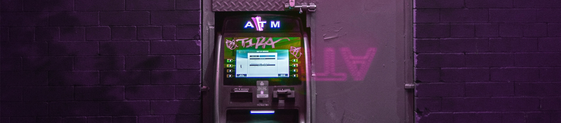 ATM machine against a purple wall ATM machine against a purple wall