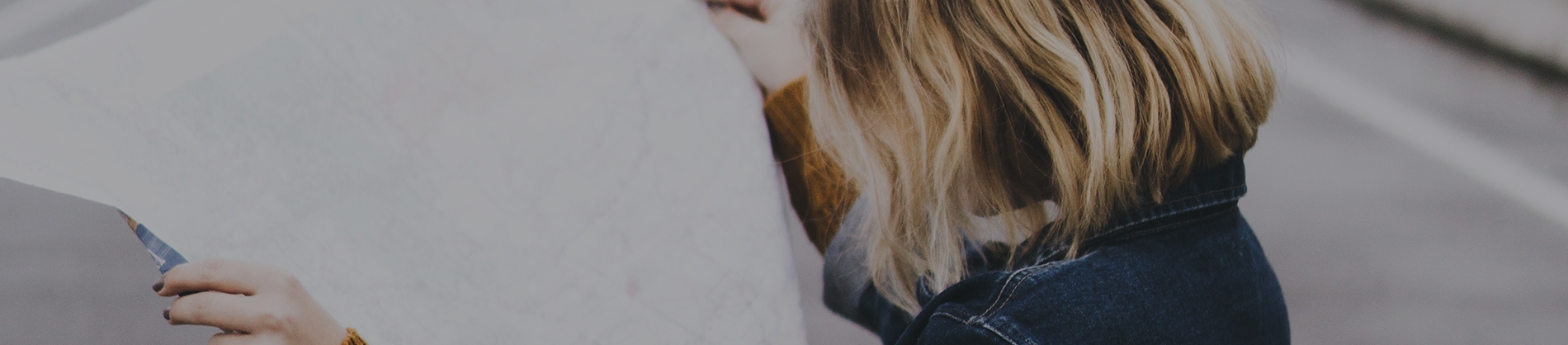 A women in a denim jacket reading a map A women in a denim jacket reading a map
