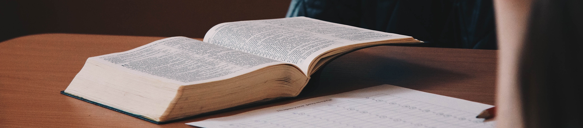 Open bible with notepaper on a wooden table Open bible with notepaper on a wooden table