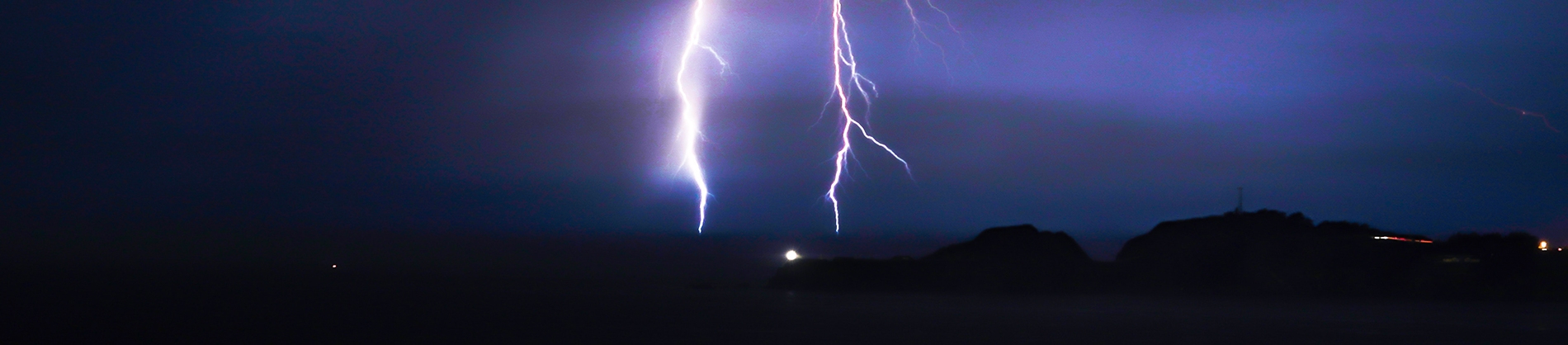 Lightening bolts flashing down on a dark landscape Lightening bolts flashing down on a dark landscape