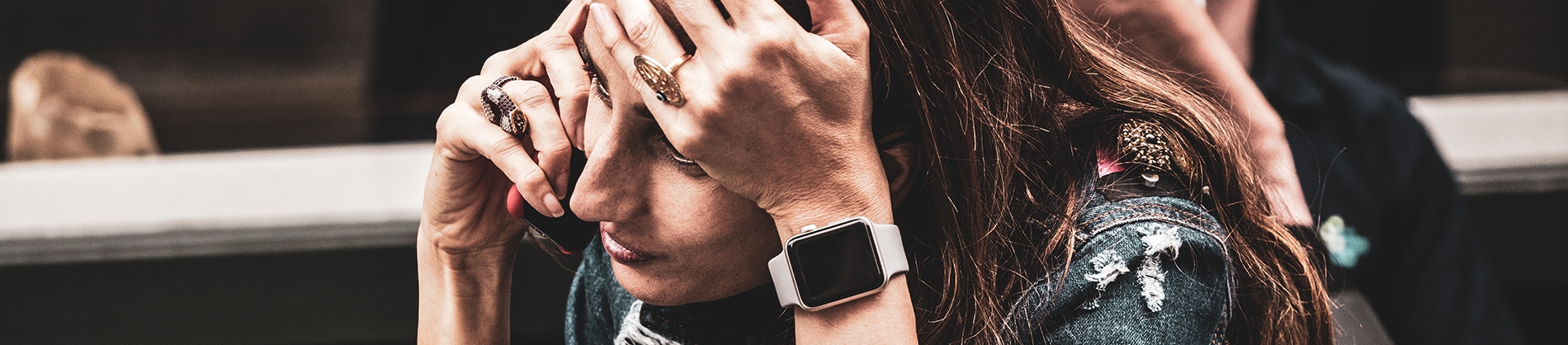A women on the phone resting her hand on her forehead A women on the phone resting her hand on her forehead