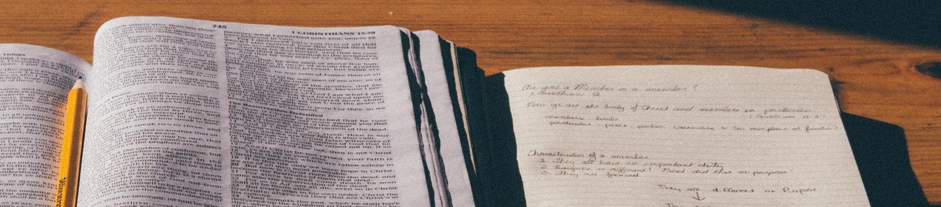Open bible with a notebook open next to it