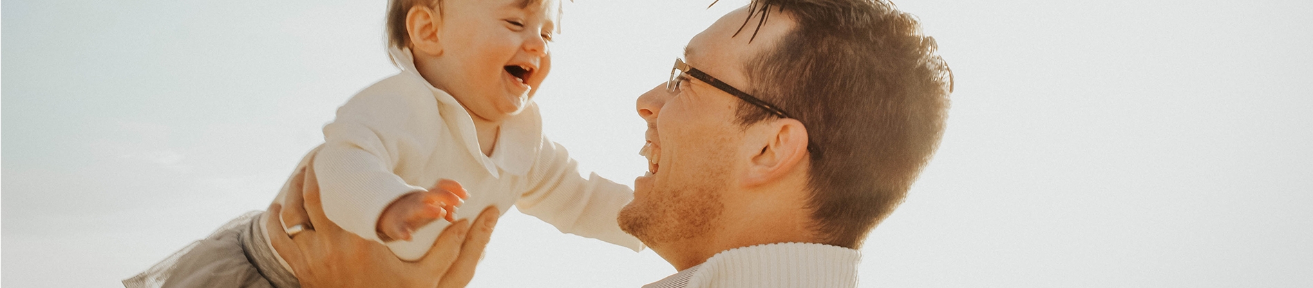 A father holding his laughing baby in the air A father holding his laughing baby in the air