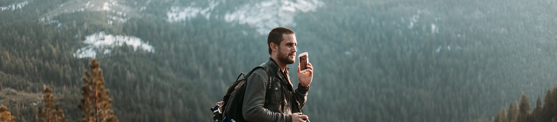 A guy high up on a mountain speaking on the phone