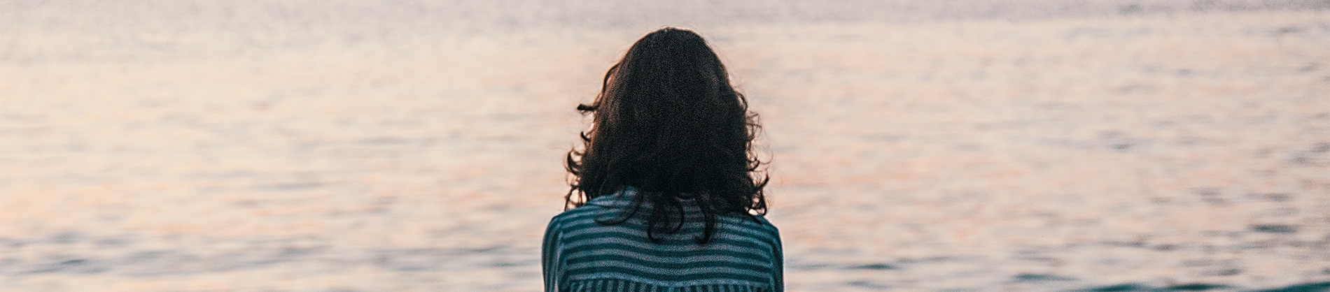 A women in a striped shirt looking out to sea A women in a striped shirt looking out to sea
