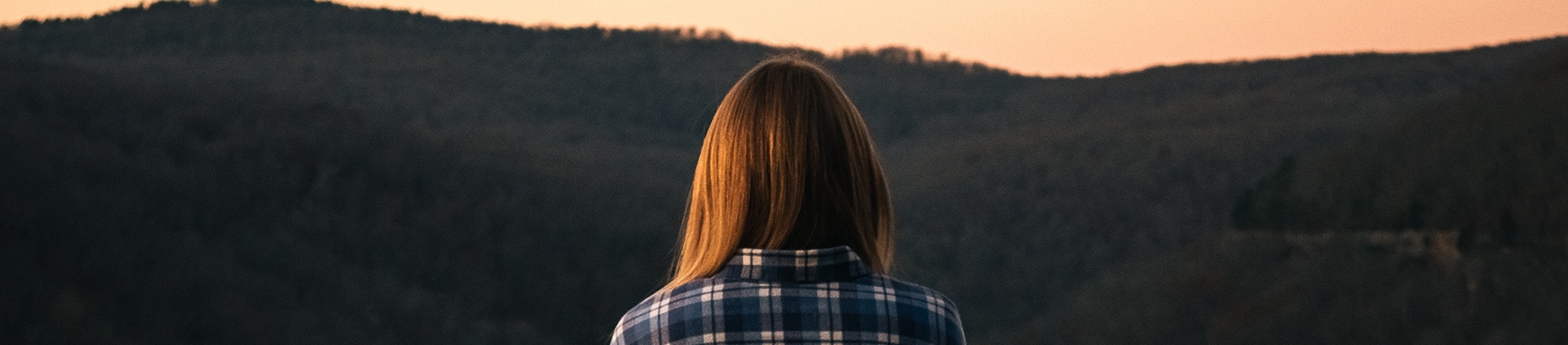 A women looking out on a landscape at sunset