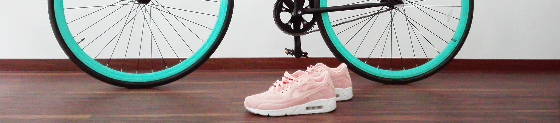 A black and Turquoise bike with pink trainers
