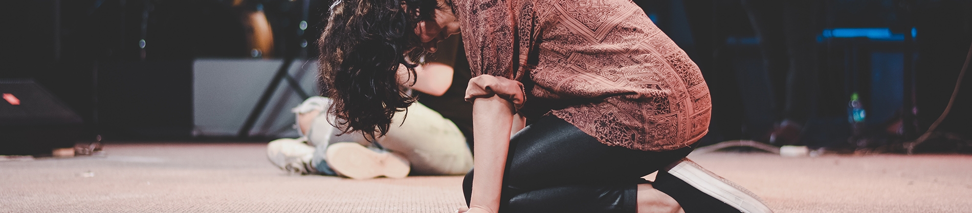 A person praying on the floor on their knees