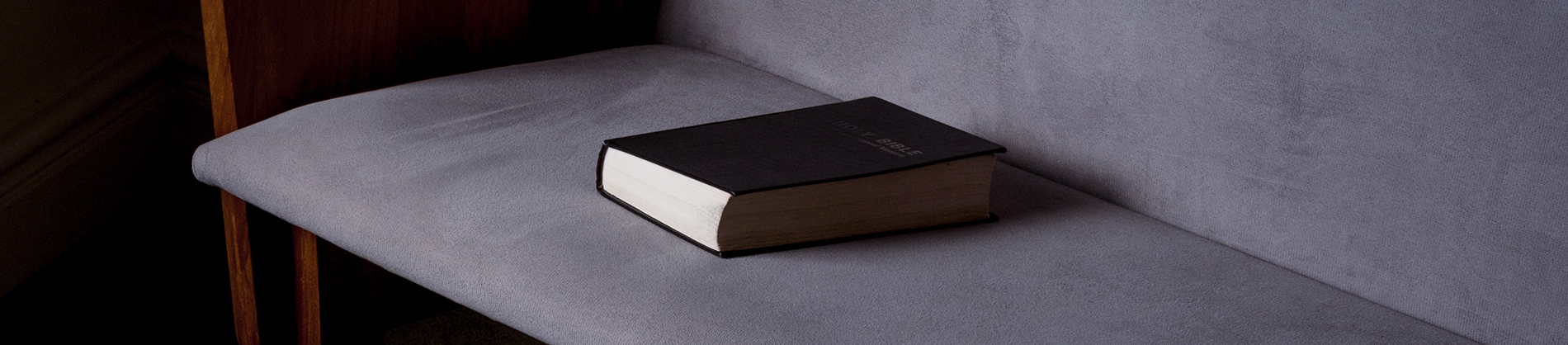 A bible resting on a grey chair A bible resting on a grey chair