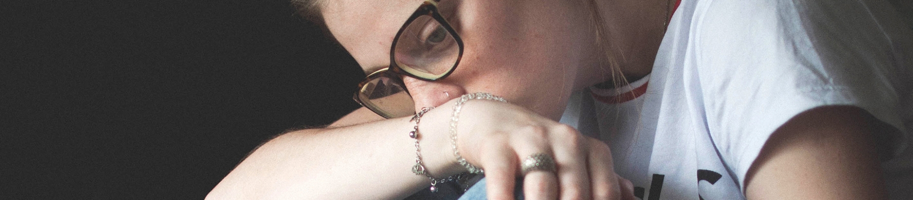 A women leaning on her arm looking sad A women leaning on her arm looking sad