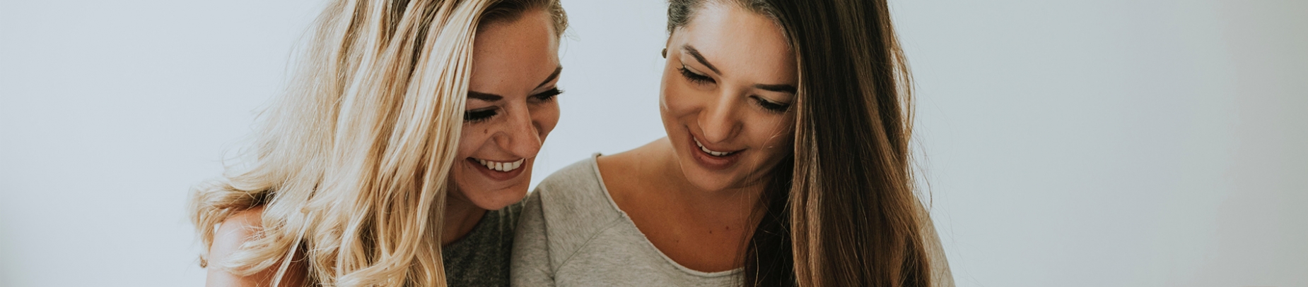 Two female friends smiling together Two female friends smiling together