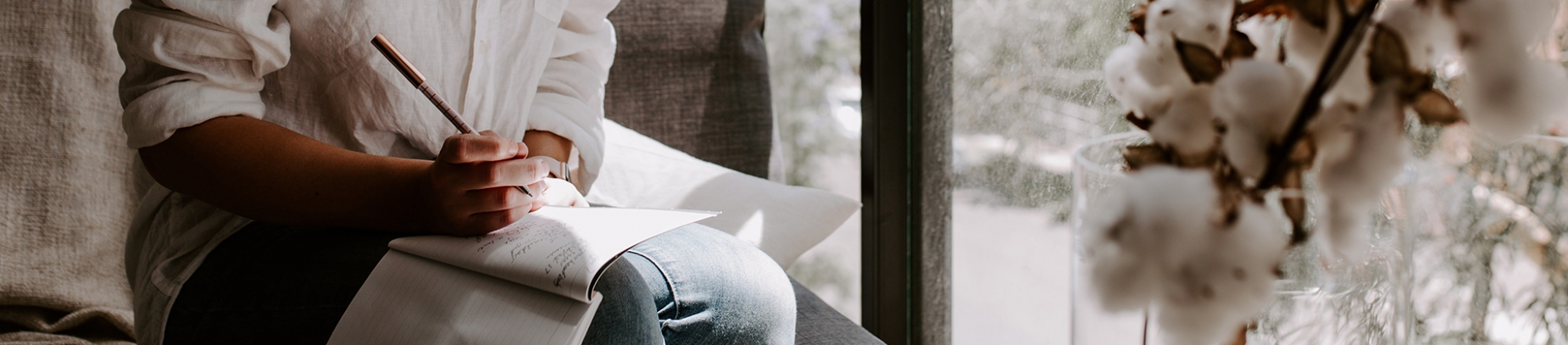A women sat on a chair writing in a notebook A women sat on a chair writing in a notebook