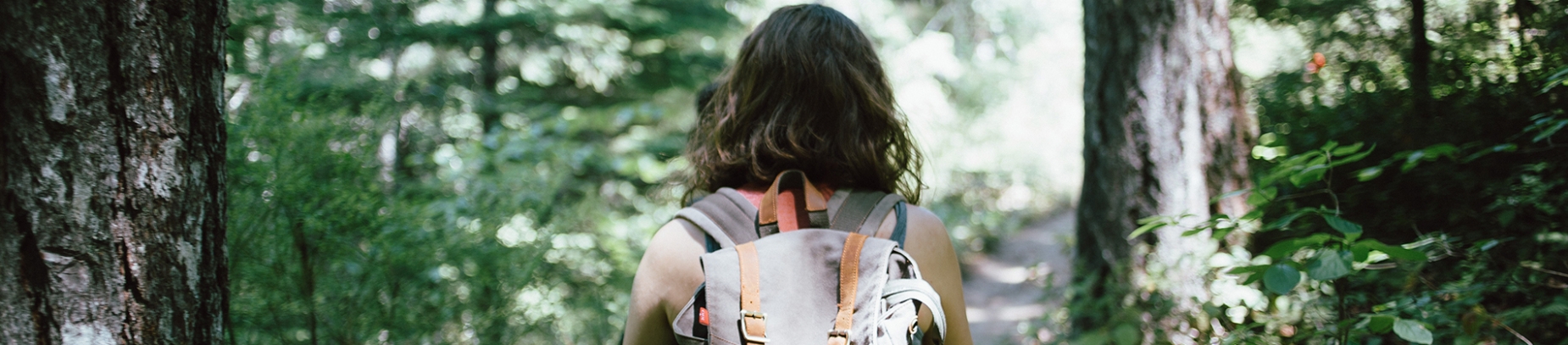 A women with a backpack walking through a forest A women with a backpack walking through a forest
