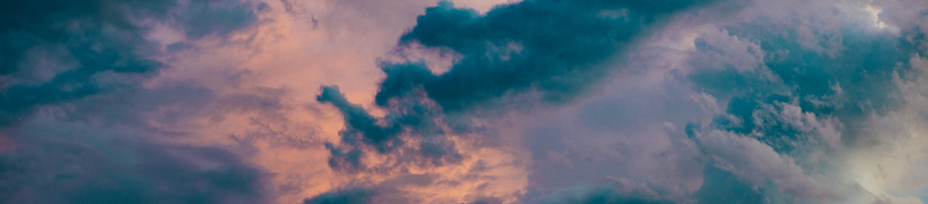 Orange, pink and blue sky with dark clouds Orange, pink and blue sky with dark clouds