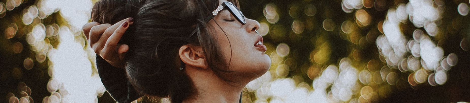 A women with her eyes closed looking up to the sky A women with her eyes closed looking up to the sky