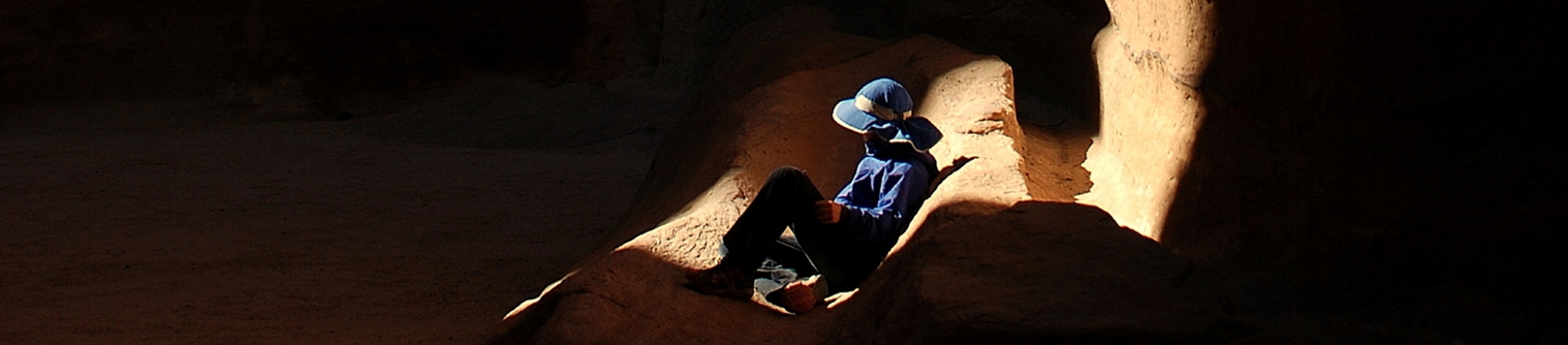 A guy sat in a cave with the light shining onto him A guy sat in a cave with the light shining onto him
