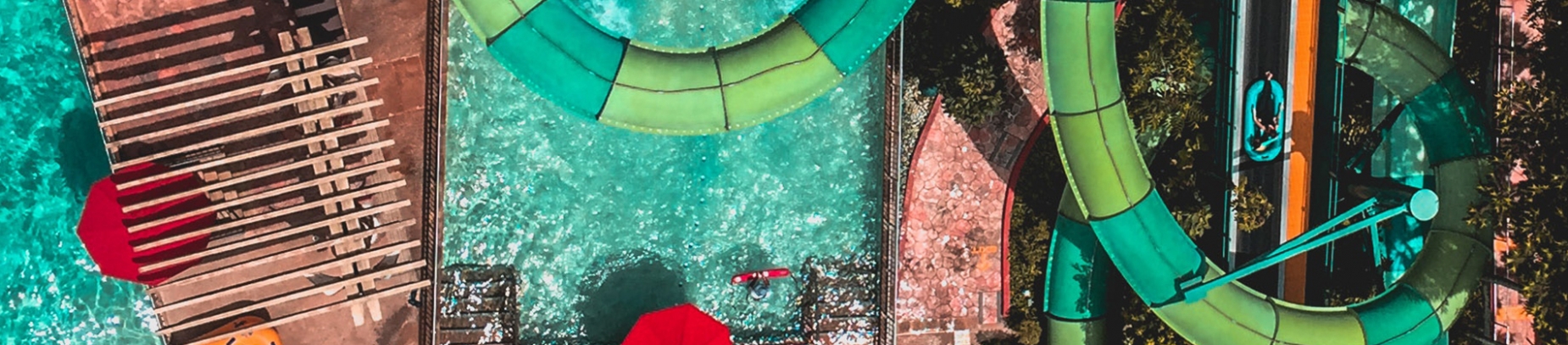 A birds-eye view of a water park with a green flume ride