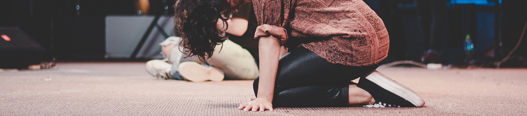 A women kneeling on the floor in prayer A women kneeling on the floor in prayer
