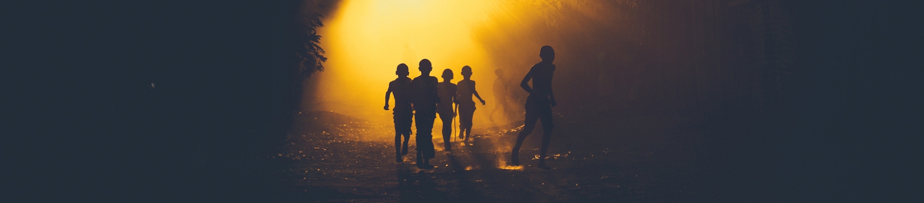 Children running down a sun lit road Children running down a sun lit road