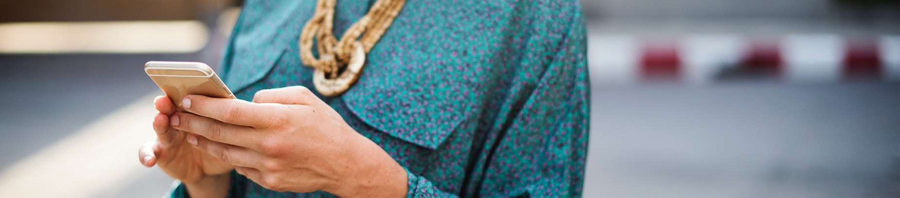 A women in a blue shirt texting on her phone
