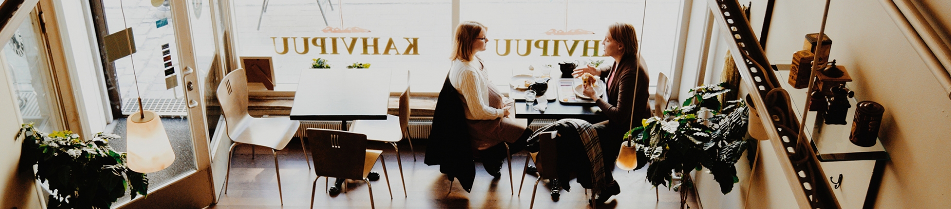 Two women sat in a cafe talking together Two women sat in a cafe talking together
