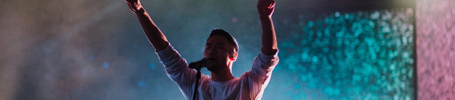 A worship leader singing with hands in the air A worship leader singing with hands in the air