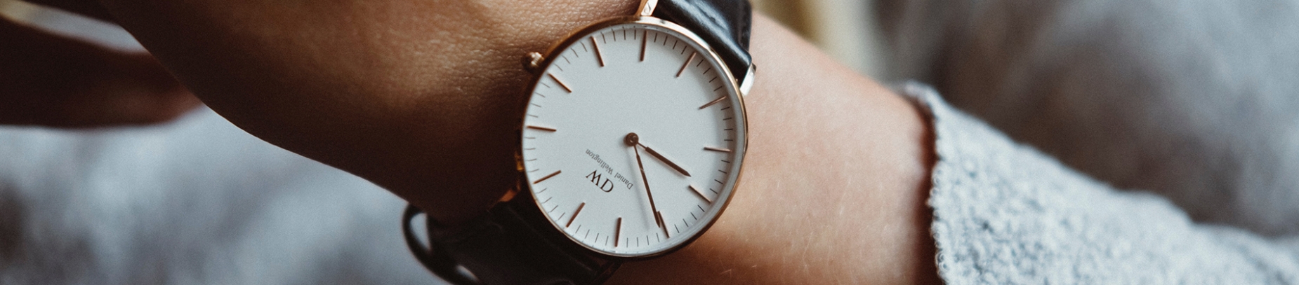 A person wearing a gold and black watch