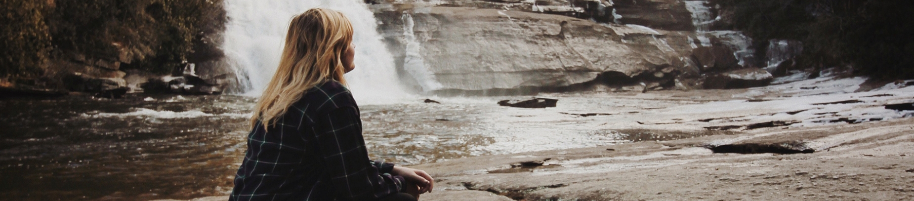 A women sat looking over a river A women sat looking over a river