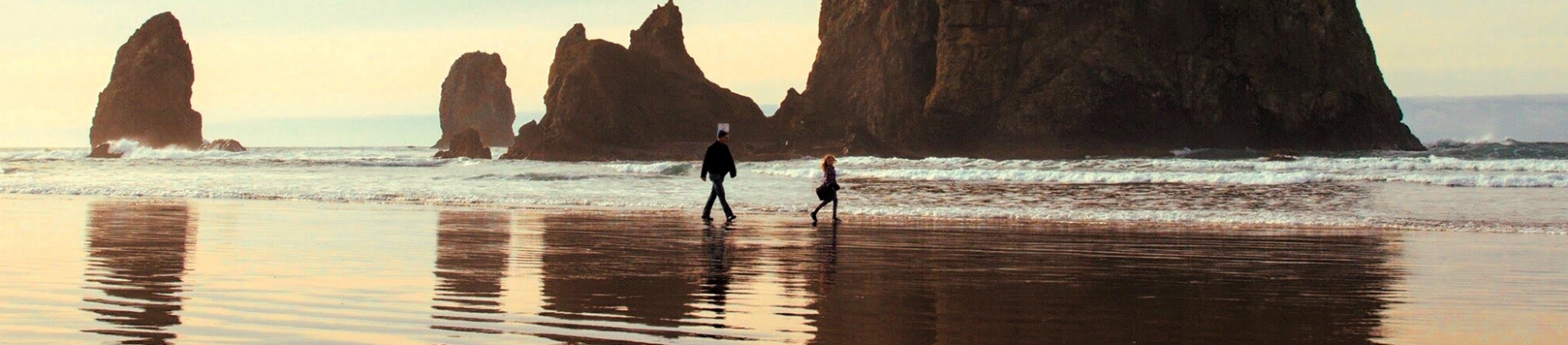 A father and child walking along a beach together A father and child walking along a beach together