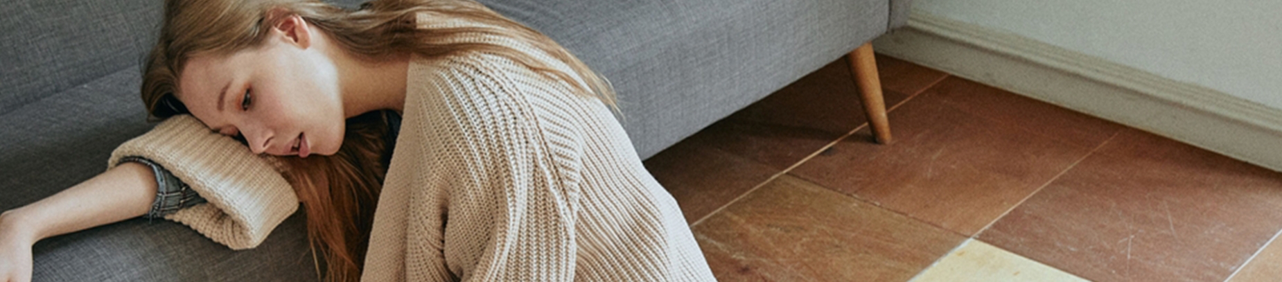 A women resting her head on her arm on a sofa A women resting her head on her arm on a sofa