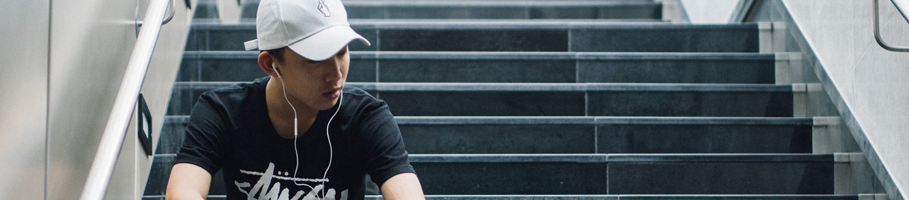 A guy sat on some steps with earphones in A guy sat on some steps with earphones in