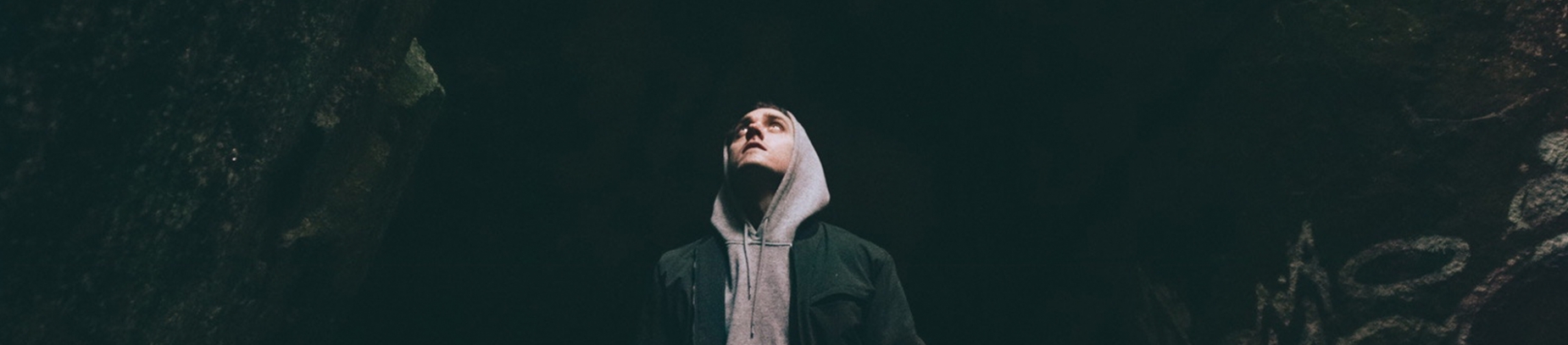 A man stood in a cave looking up A man stood in a cave looking up