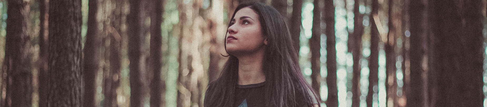 A girl in a forest looking up to the sky A girl in a forest looking up to the sky