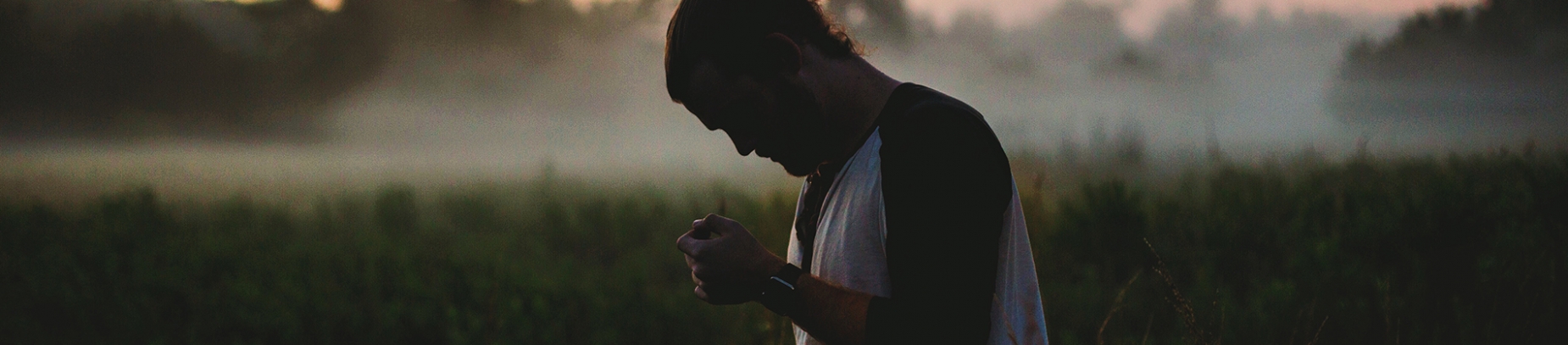 A man stood in a misty field with his head down A man stood in a misty field with his head down