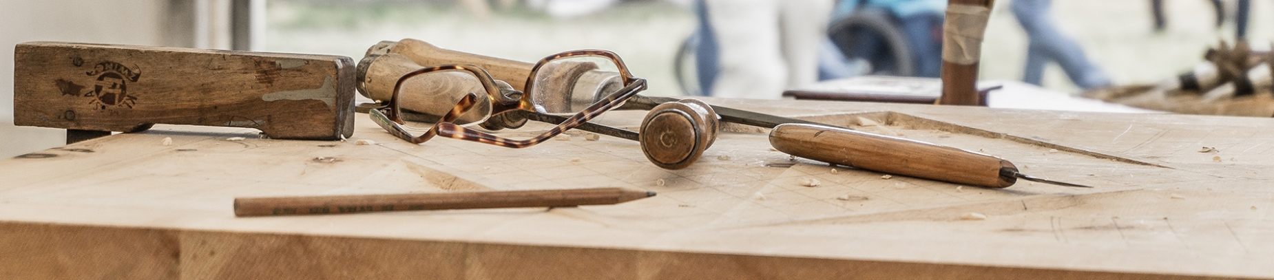 A wooden workbench with tools laying on top A wooden workbench with tools laying on top