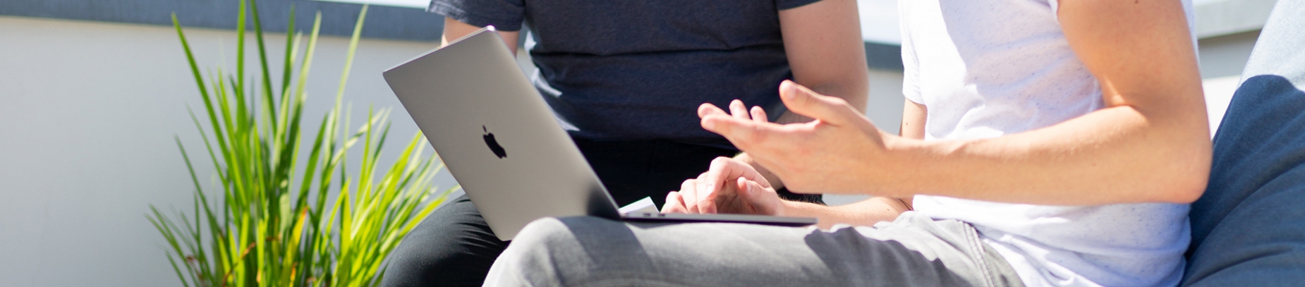 Two guys sat talking and looking at a laptop Two guys sat talking and looking at a laptop